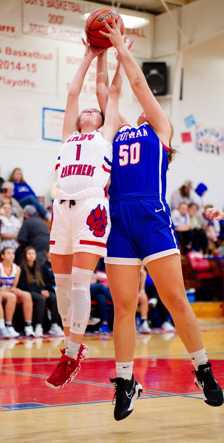 Lady Panther Kalli Trimble leaps for the rebound against Lady Bulldog Annabelle Popek. [see more shots, buy basketball photos]